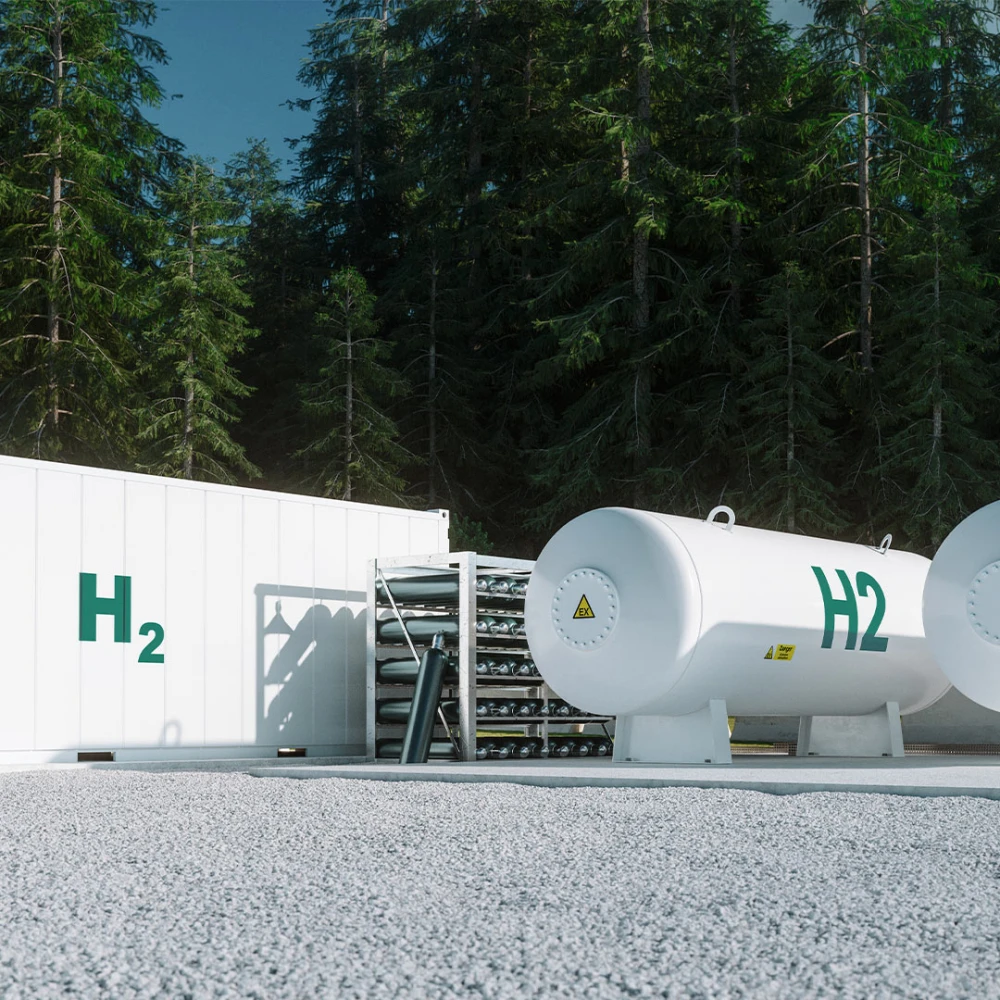 Hydrogen storage facility in a pine forest featuring two large white tanks and a building, all labeled H2