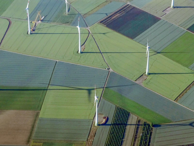 Aerial view of wind turbines in an agricultural area with various fields