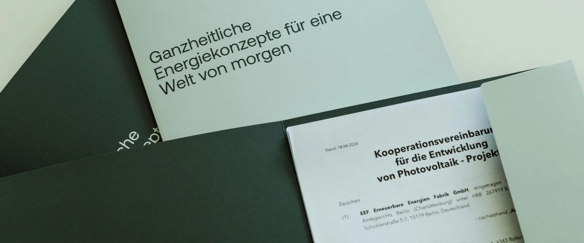 Geöffnete Broschüren und Dokumente zu Energiekonzepten und Kooperationsvereinbarungen für Photovoltaik-Projekte auf einem Tisch