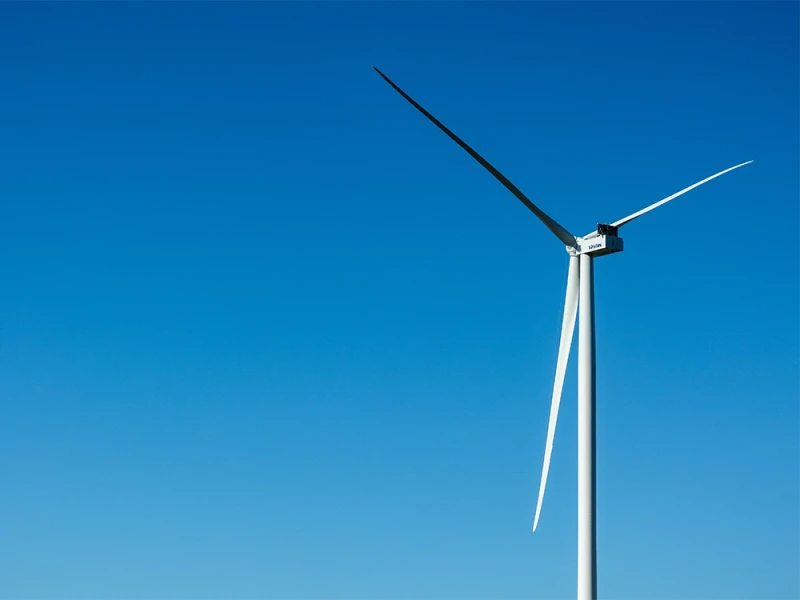 Ein einzelnes Windrad vor klarem, blauem Himmel – Symbol für erneuerbare Energien und nachhaltige Stromerzeugung.