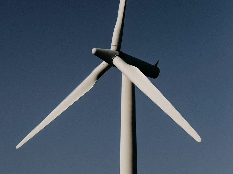 Nahaufnahme einer Windturbine gegen einen klaren blauen Himmel