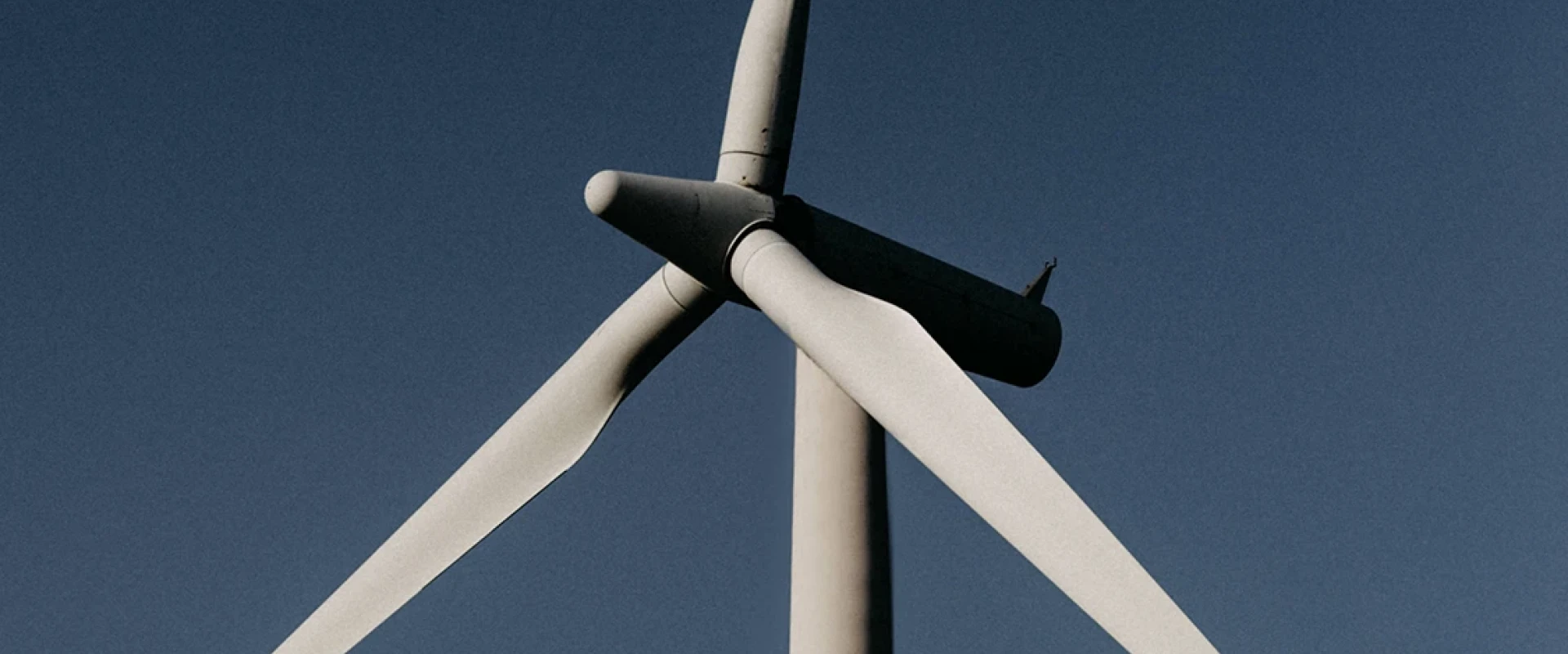 Nahaufnahme einer Windturbine gegen einen klaren blauen Himmel